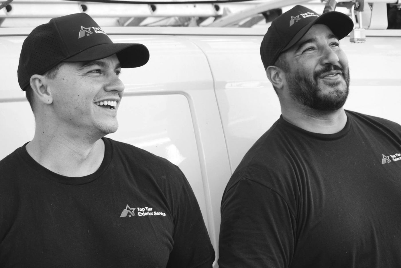Zach Rubio and Joey Alvarez standing beside a work van